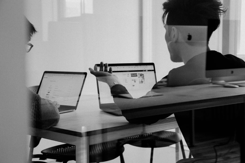 Two people talk with each other discussed about something in front of their laptop